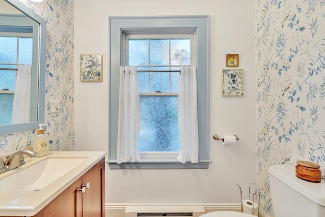 half bath featuring toilet, wallpapered walls, and vanity