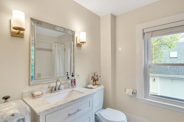 bathroom featuring toilet, vanity, and a shower with curtain