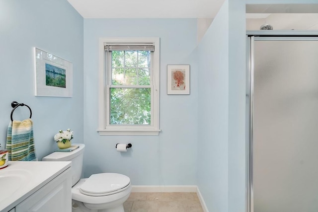 bathroom featuring toilet, vanity, baseboards, a shower with door, and tile patterned floors