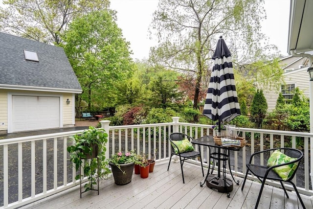 deck featuring outdoor dining area and a garage