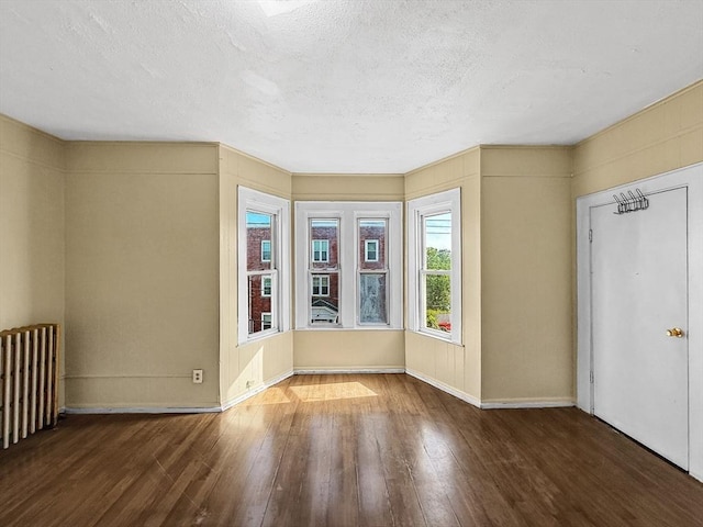 19 High St, Lynn, MA 01902 - spare room featuring hardwood / wood-style flooring, a textured ceiling, and radiator