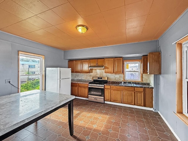 19 High St, Lynn, MA 01902 - kitchen featuring gas range, freestanding refrigerator, brown cabinets, decorative backsplash, and healthy amount of natural light