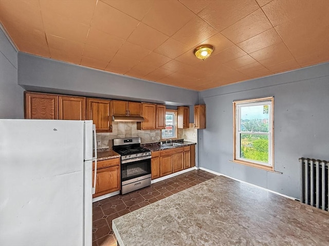 19 High St, Lynn, MA 01902 - kitchen with freestanding refrigerator, stainless steel range with gas cooktop, under cabinet range hood, brown cabinets, and plenty of natural light