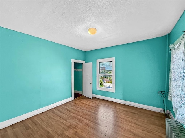 19 High St, Lynn, MA 01902 - unfurnished bedroom featuring wood finished floors and a textured ceiling