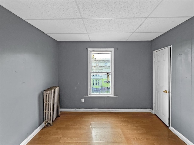 19 High St, Lynn, MA 01902 - unfurnished bedroom with radiator heating unit, a drop ceiling, and wood finished floors