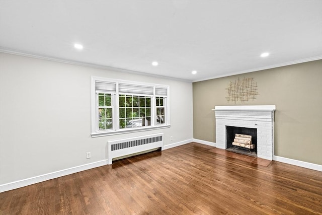 181 Manchester St, Boston, MA 02126 - unfurnished living room with radiator, crown molding, a brick fireplace, wood finished floors, and recessed lighting