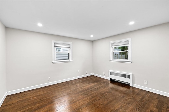 181 Manchester St, Boston, MA 02126 - empty room featuring radiator heating unit, healthy amount of natural light, wood finished floors, and recessed lighting
