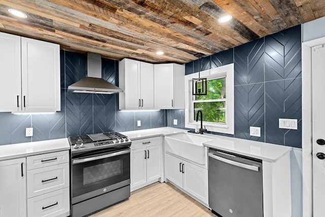 181 Manchester St, Boston, MA 02126 - kitchen featuring appliances with stainless steel finishes, wall chimney range hood, wood ceiling, light countertops, and light wood-style floors