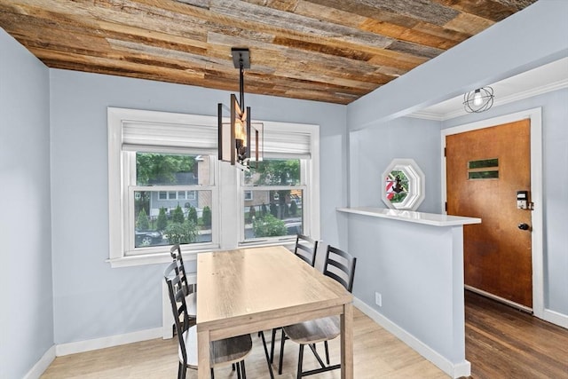 181 Manchester St, Boston, MA 02126 - dining space featuring a chandelier, wood finished floors, wooden ceiling, and crown molding