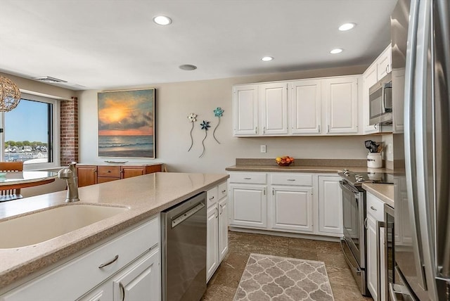 kitchen featuring a sink, appliances with stainless steel finishes, and white cabinets