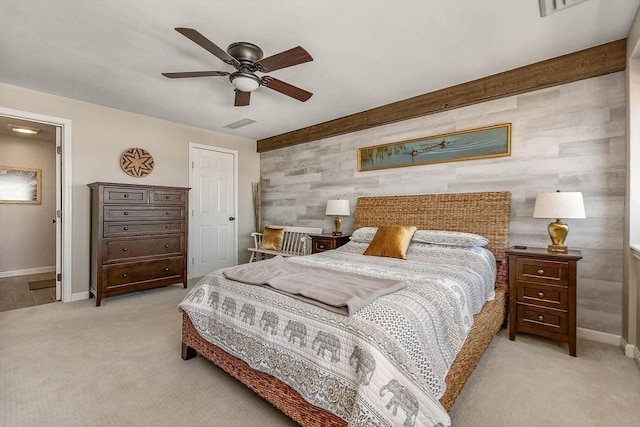 bedroom with carpet flooring, baseboards, wood walls, and ceiling fan
