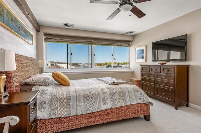 bedroom with light colored carpet, ceiling fan, visible vents, and baseboards