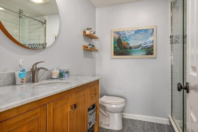 bathroom with vanity, baseboards, toilet, and a shower stall
