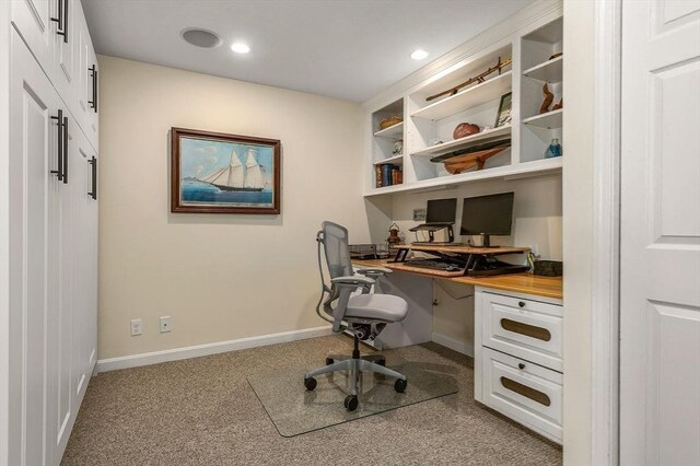 home office with carpet flooring, baseboards, and built in desk