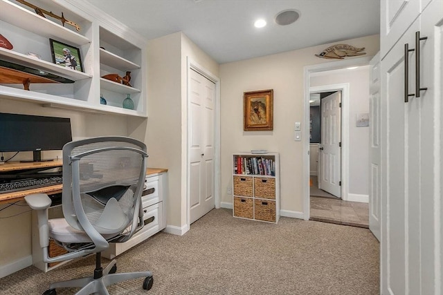 home office with baseboards and light carpet