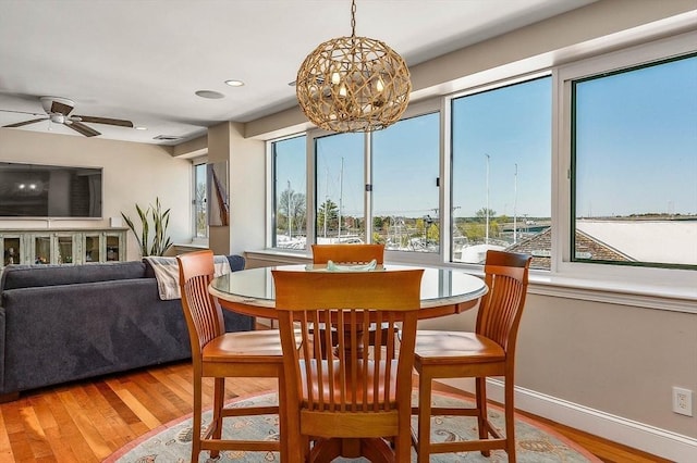 dining room featuring baseboards, recessed lighting, ceiling fan with notable chandelier, and wood finished floors