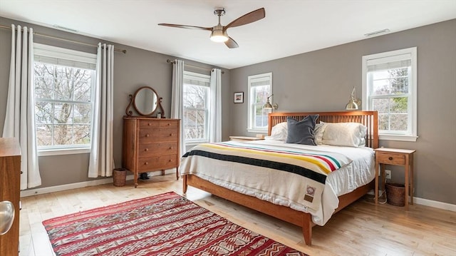 60 Wright St, Arlington, MA 02474 - bedroom with light wood-type flooring, multiple windows, baseboards, and a ceiling fan