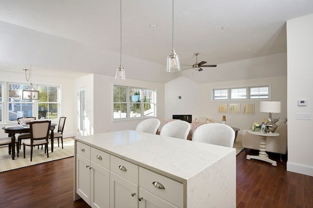 kitchen featuring dark hardwood / wood-style flooring, decorative light fixtures, and white cabinetry