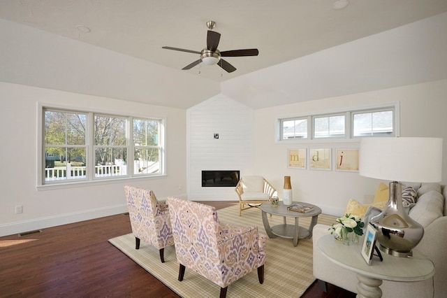 living room with a fireplace, dark hardwood / wood-style flooring, brick wall, ceiling fan, and lofted ceiling