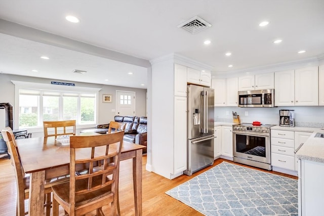18 Tupelo, Harwich, MA 02645 - kitchen with stainless steel appliances, light wood-type flooring, recessed lighting, white cabinetry, and light stone countertops