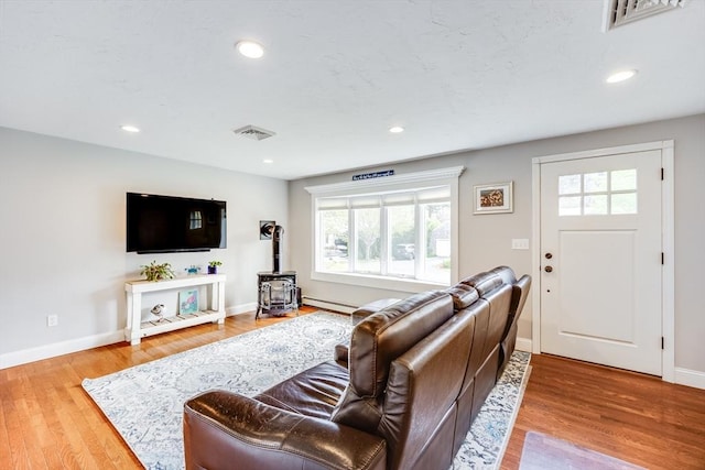 18 Tupelo, Harwich, MA 02645 - living room featuring a wood stove, a baseboard radiator, healthy amount of natural light, baseboards, and recessed lighting