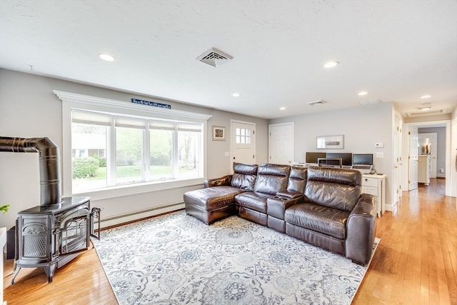 18 Tupelo, Harwich, MA 02645 - living area with baseboard heating, light wood-style flooring, recessed lighting, a wood stove, and baseboards