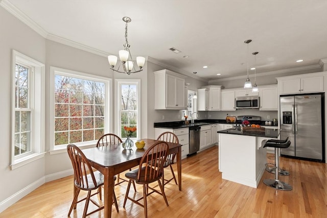 30 Compass Pt Unit 30, North Andover, MA 01845 - kitchen featuring stainless steel appliances, a chandelier, ornamental molding, a kitchen island, and white cabinetry