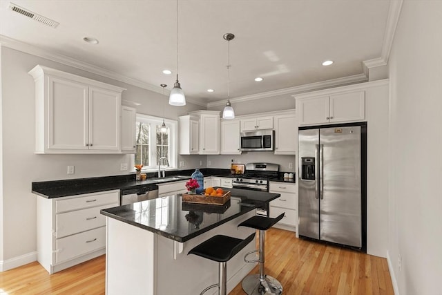 30 Compass Pt Unit 30, North Andover, MA 01845 - kitchen with appliances with stainless steel finishes, white cabinetry, light wood-style floors, ornamental molding, and a breakfast bar
