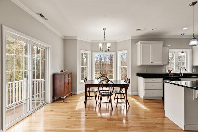 30 Compass Pt Unit 30, North Andover, MA 01845 - dining area with healthy amount of natural light, light wood finished floors, a chandelier, and crown molding