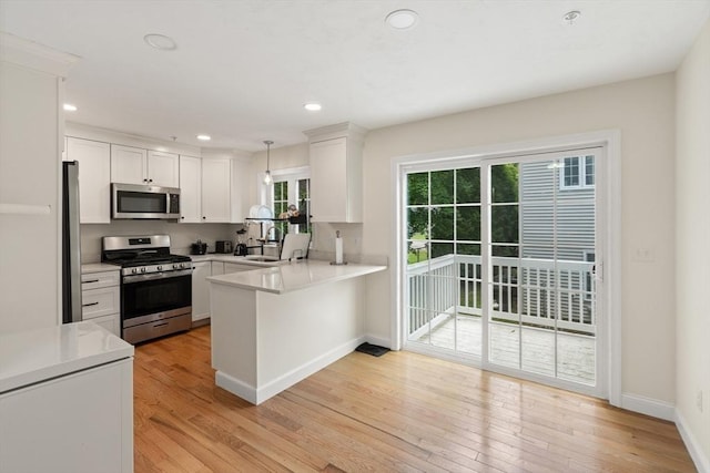 35 Fredonian St Unit K, Shirley, MA 01464 - kitchen with stainless steel appliances, a peninsula, light countertops, light wood-style flooring, and recessed lighting