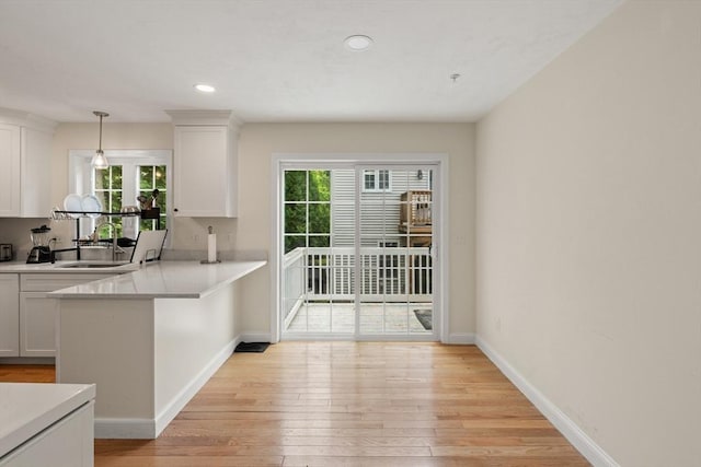35 Fredonian St Unit K, Shirley, MA 01464 - kitchen featuring healthy amount of natural light, white cabinets, light wood-type flooring, light countertops, and recessed lighting