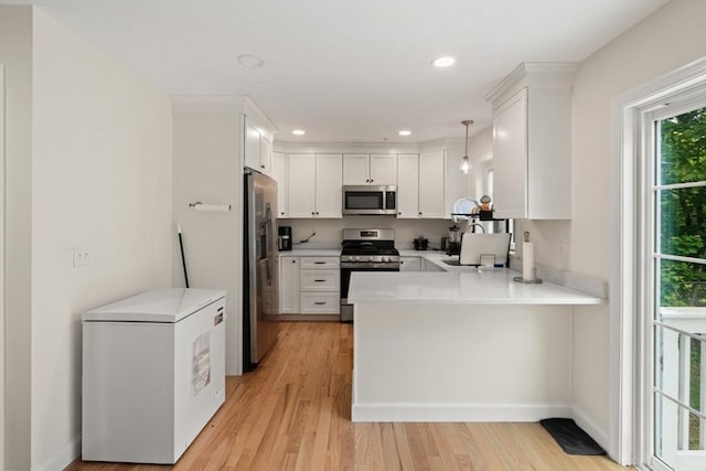 35 Fredonian St Unit K, Shirley, MA 01464 - kitchen featuring appliances with stainless steel finishes, a peninsula, light countertops, light wood finished floors, and recessed lighting