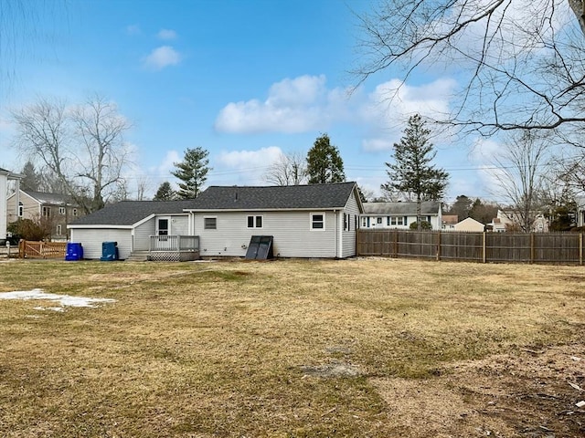 back of house with a wooden deck and a lawn