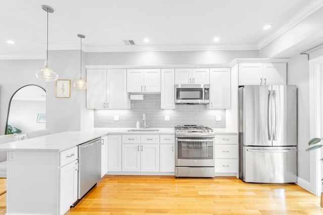 37-39 Lamson St Unit 2, Boston, MA 02128 - kitchen with appliances with stainless steel finishes, a sink, a peninsula, white cabinetry, and light wood-style floors