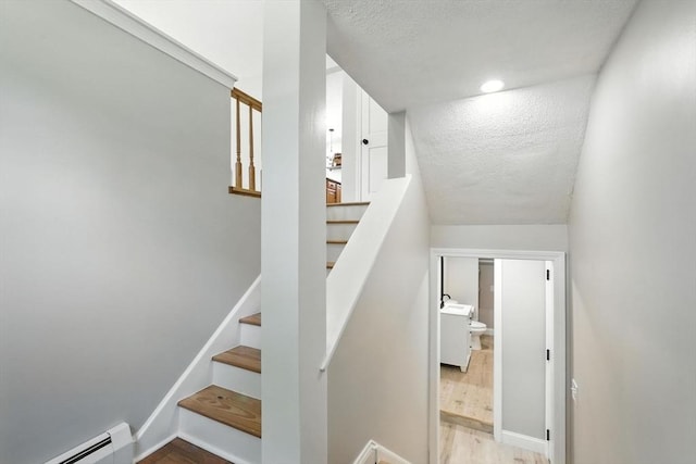 147 Mort Vining Rd, Southwick, MA 01077 - staircase featuring baseboard heating, a textured ceiling, wood finished floors, and recessed lighting