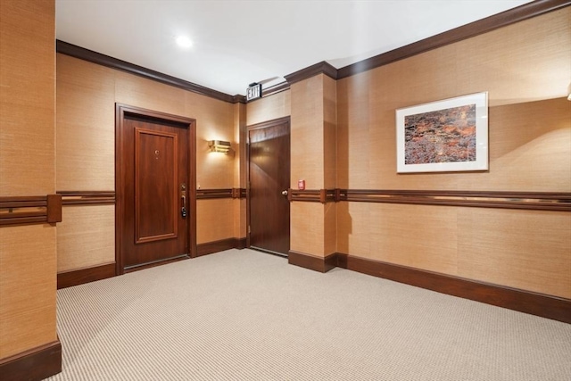 hallway with crown molding and light colored carpet