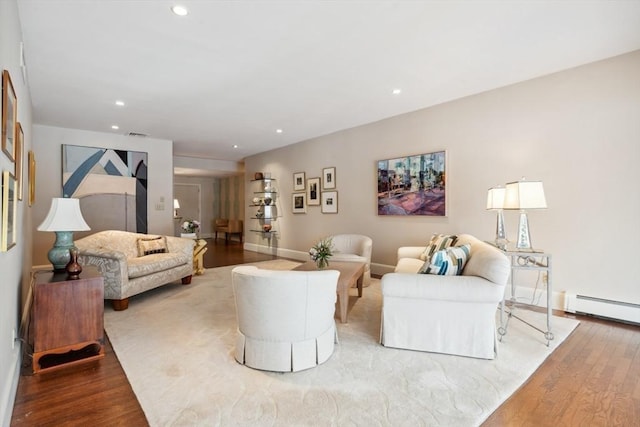 living room with baseboard heating and light hardwood / wood-style flooring