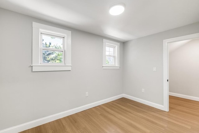 spare room with light wood finished floors, healthy amount of natural light, and baseboards