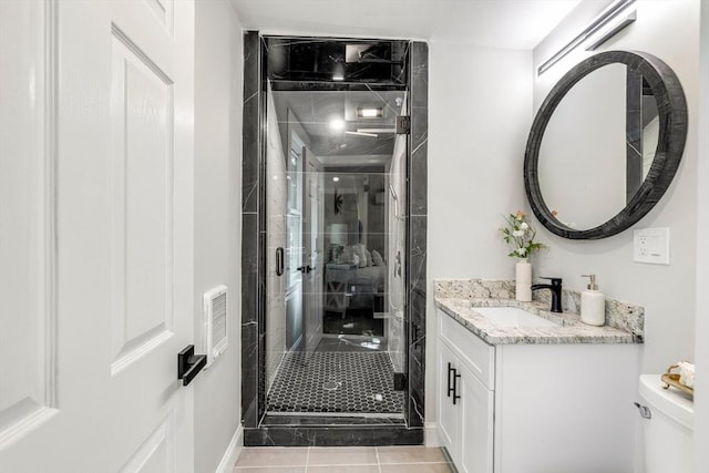 full bath featuring vanity, toilet, a stall shower, and tile patterned flooring