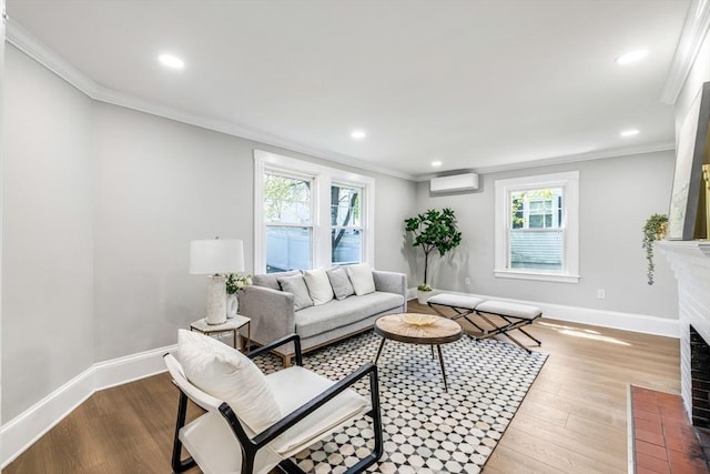 living room featuring a wall mounted AC, baseboards, wood finished floors, a brick fireplace, and ornamental molding