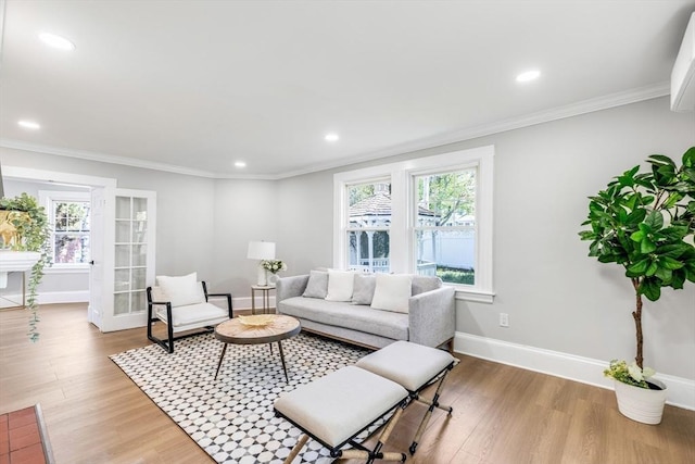 living area with healthy amount of natural light, baseboards, light wood-type flooring, ornamental molding, and recessed lighting