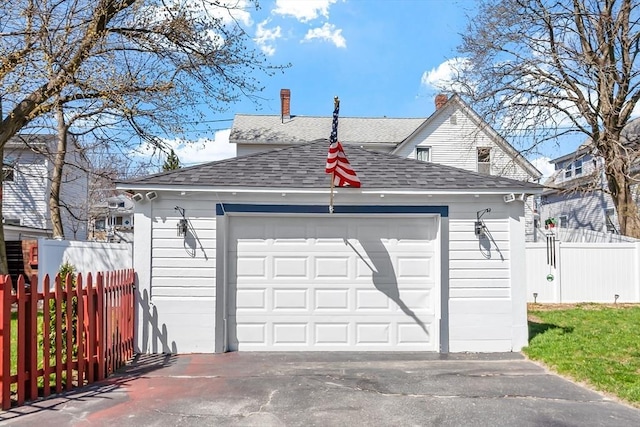 detached garage with fence and driveway