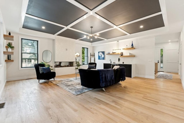 living room featuring coffered ceiling and light wood-type flooring