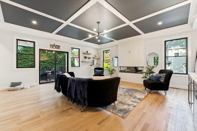 living room with beamed ceiling, a notable chandelier, light hardwood / wood-style flooring, and coffered ceiling