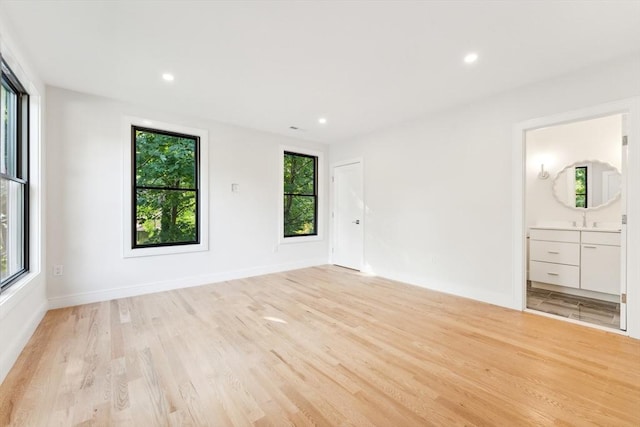 unfurnished room featuring sink and light hardwood / wood-style floors