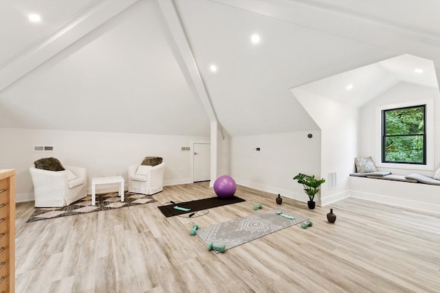 workout area featuring light hardwood / wood-style floors and lofted ceiling