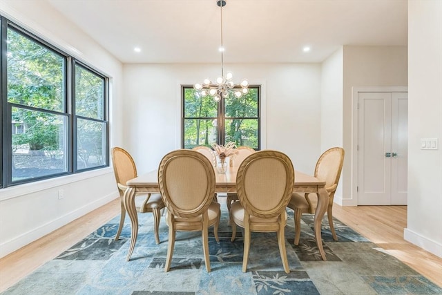 dining area featuring wood-type flooring and a notable chandelier