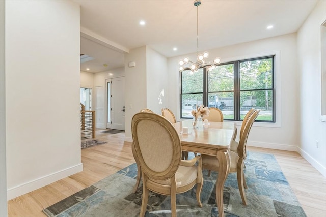 dining area featuring light wood-type flooring and an inviting chandelier