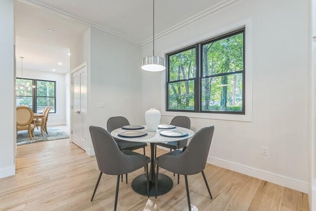 dining room with light hardwood / wood-style floors and ornamental molding