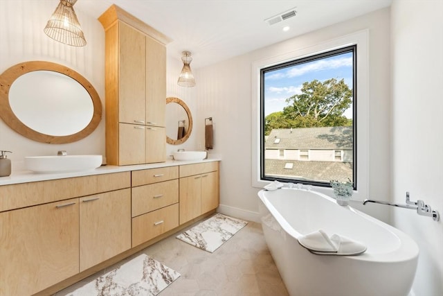 bathroom featuring a washtub, vanity, and tile patterned flooring